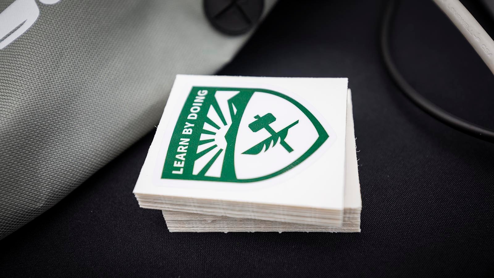 Stack of stickers of the Cal Poly shield sits on a table.