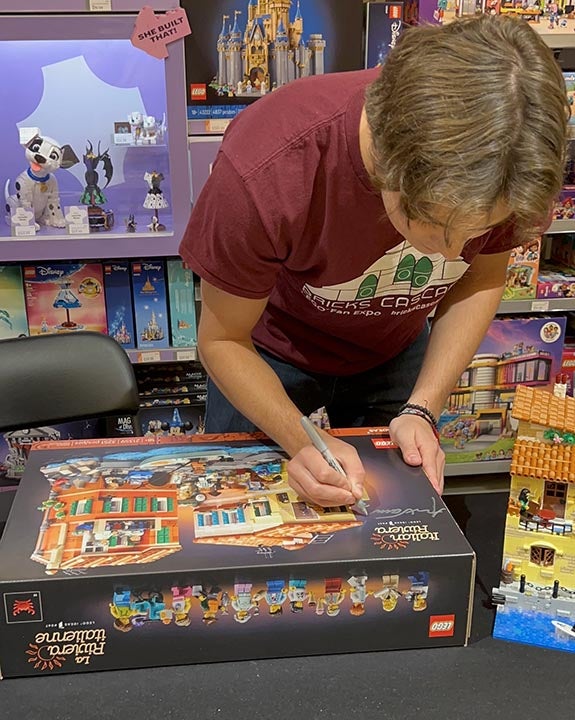 Cal Poly student Alex Sahli autographs the Lego Italian Riviera box