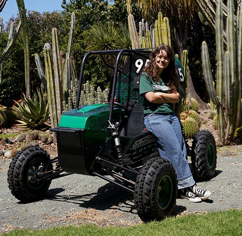 Lucia Giacalone leaning on the Cal Poly Racing SAE offroad Baja car