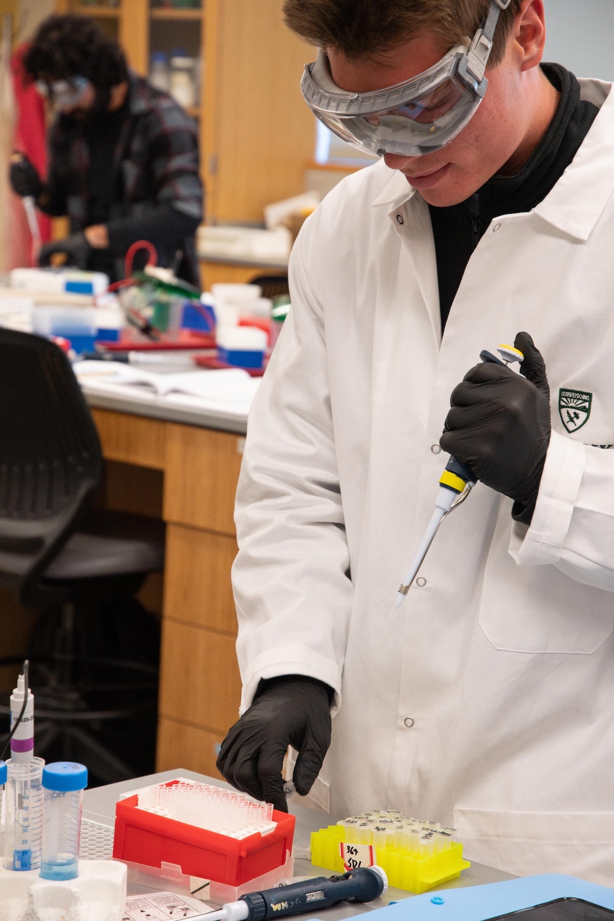 A biochemistry student works in lab in the new Engineering Synthetic Cells course 