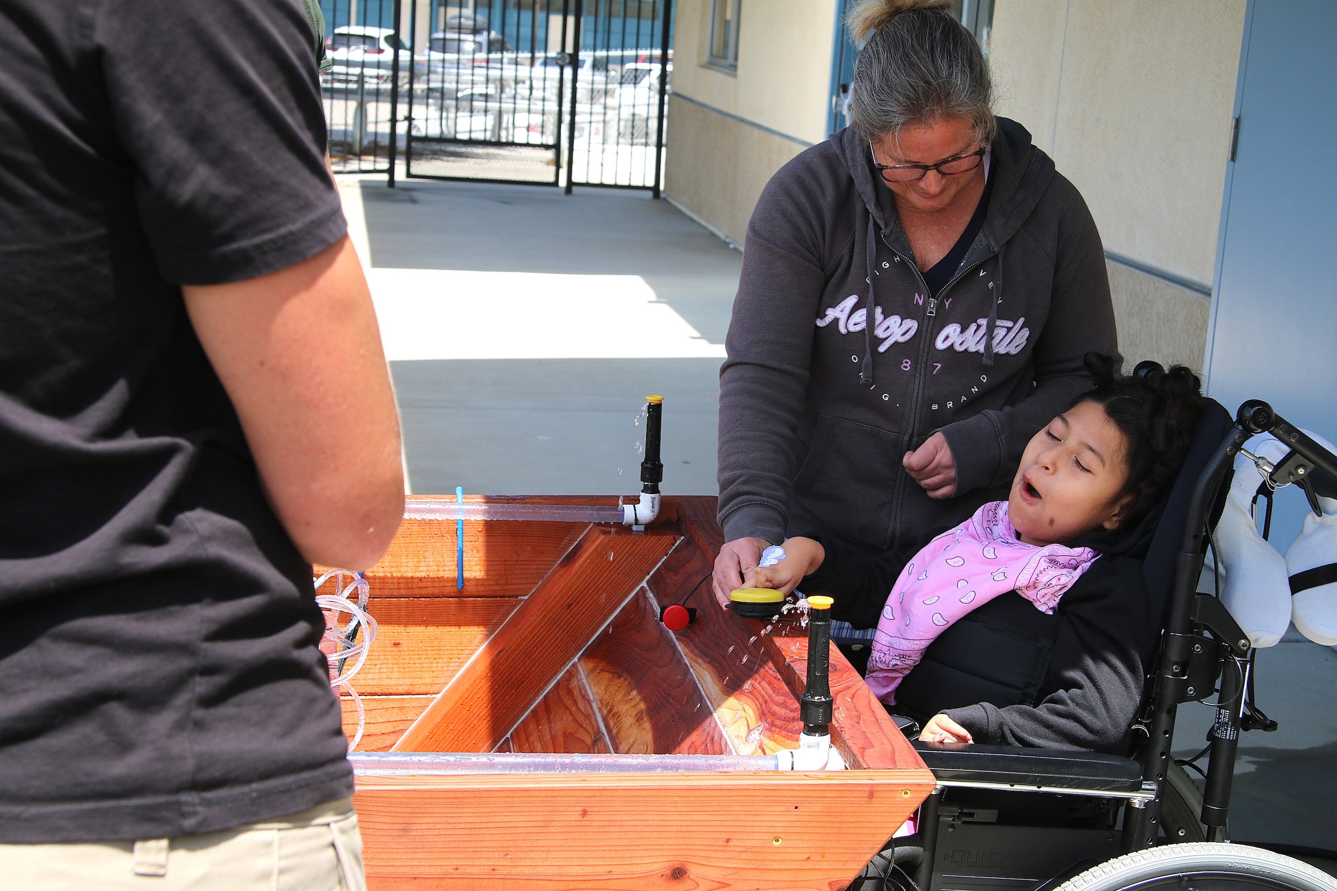 Heather McColley guides Marion as she presses a button on the garden box during the project’s first use at Oceano Elementary School.