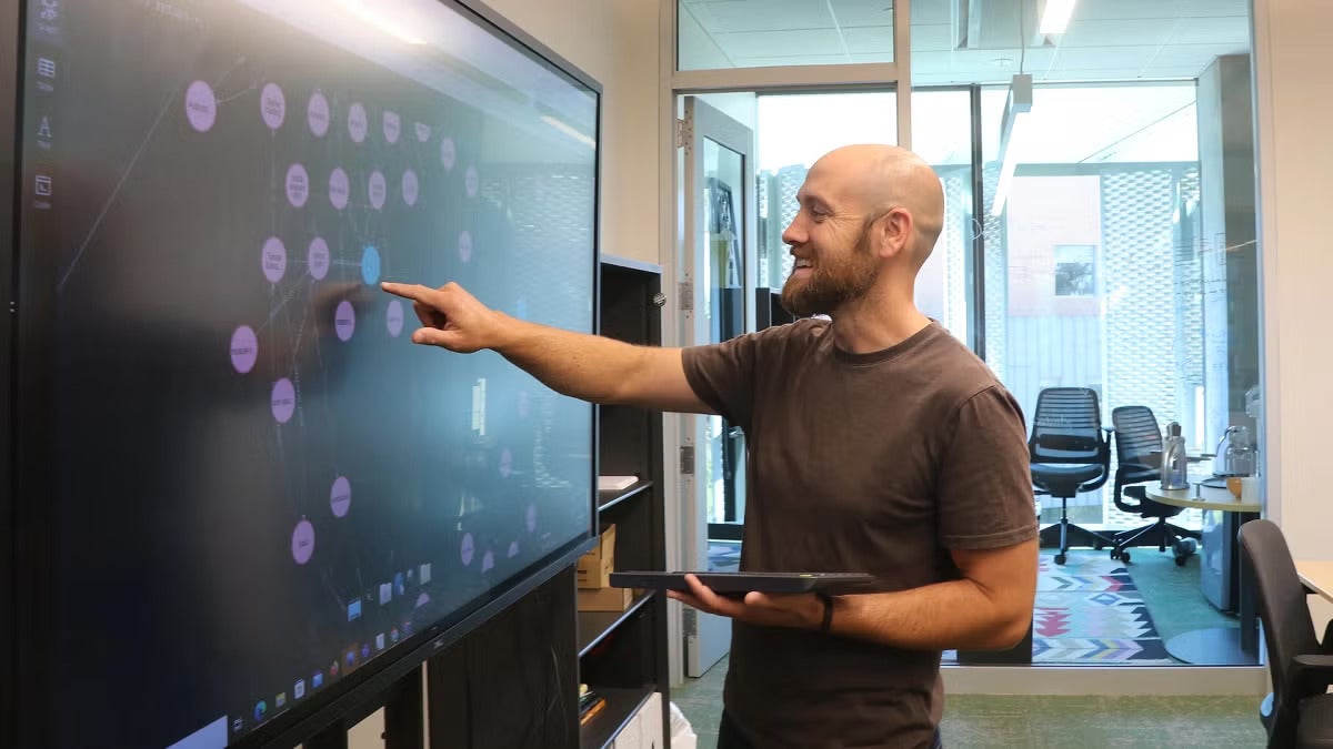Paul Anderson, Cal Poly computer science professor, pointing to a large screen