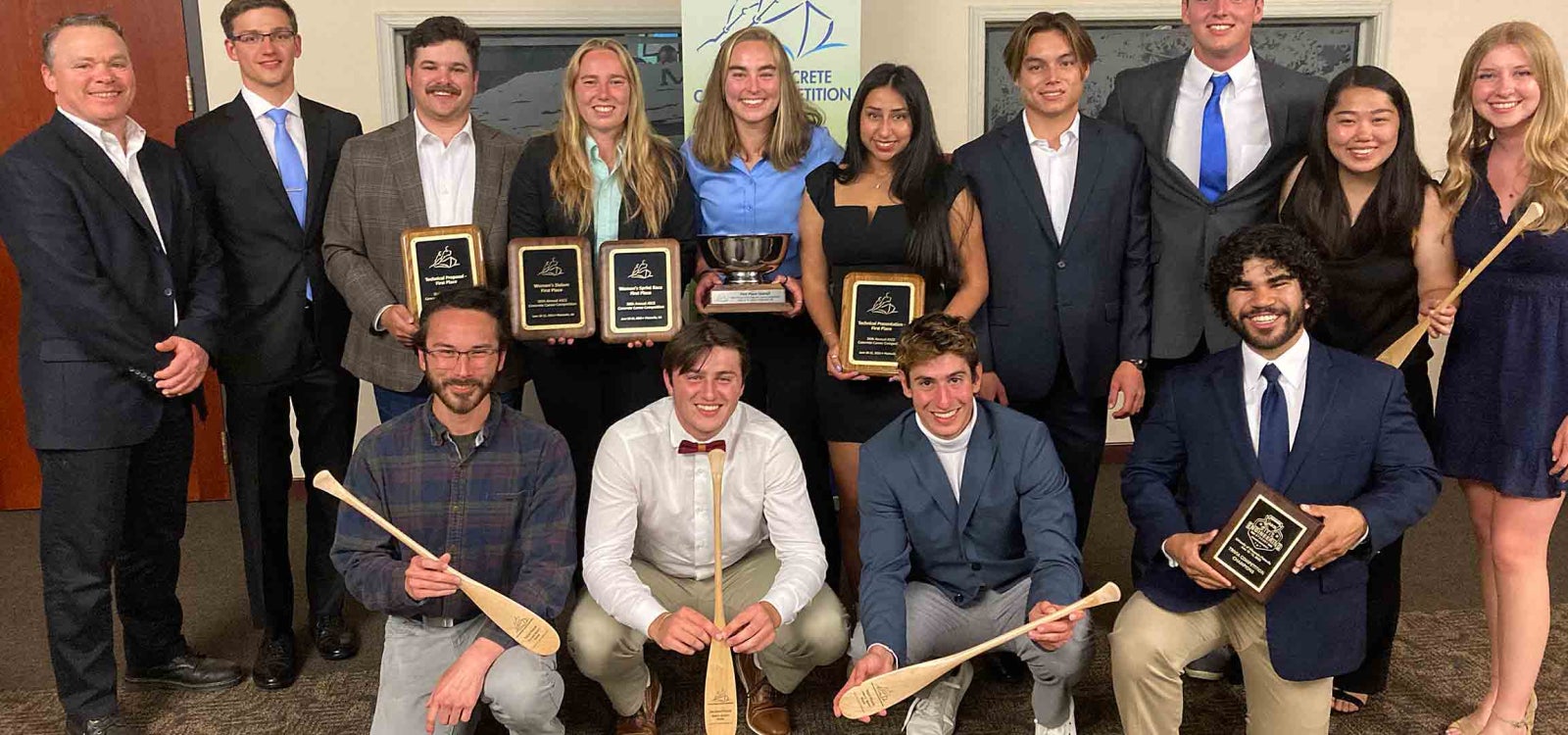 Cal Poly concrete canoe team pose with trophies including the silver national championship bowl