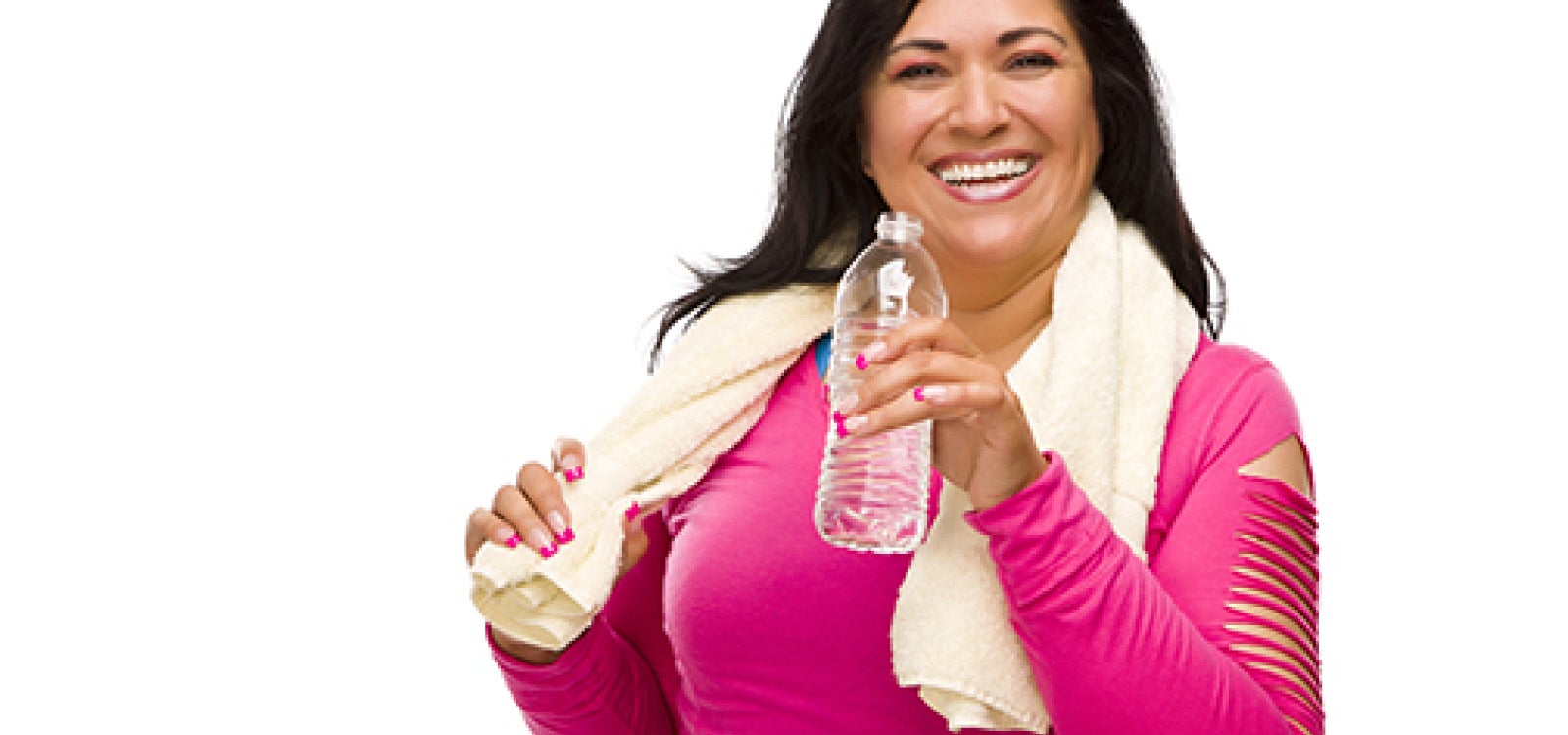 A smiling woman in a pink warmup suit with a towel over her shoulders holds a water bottle