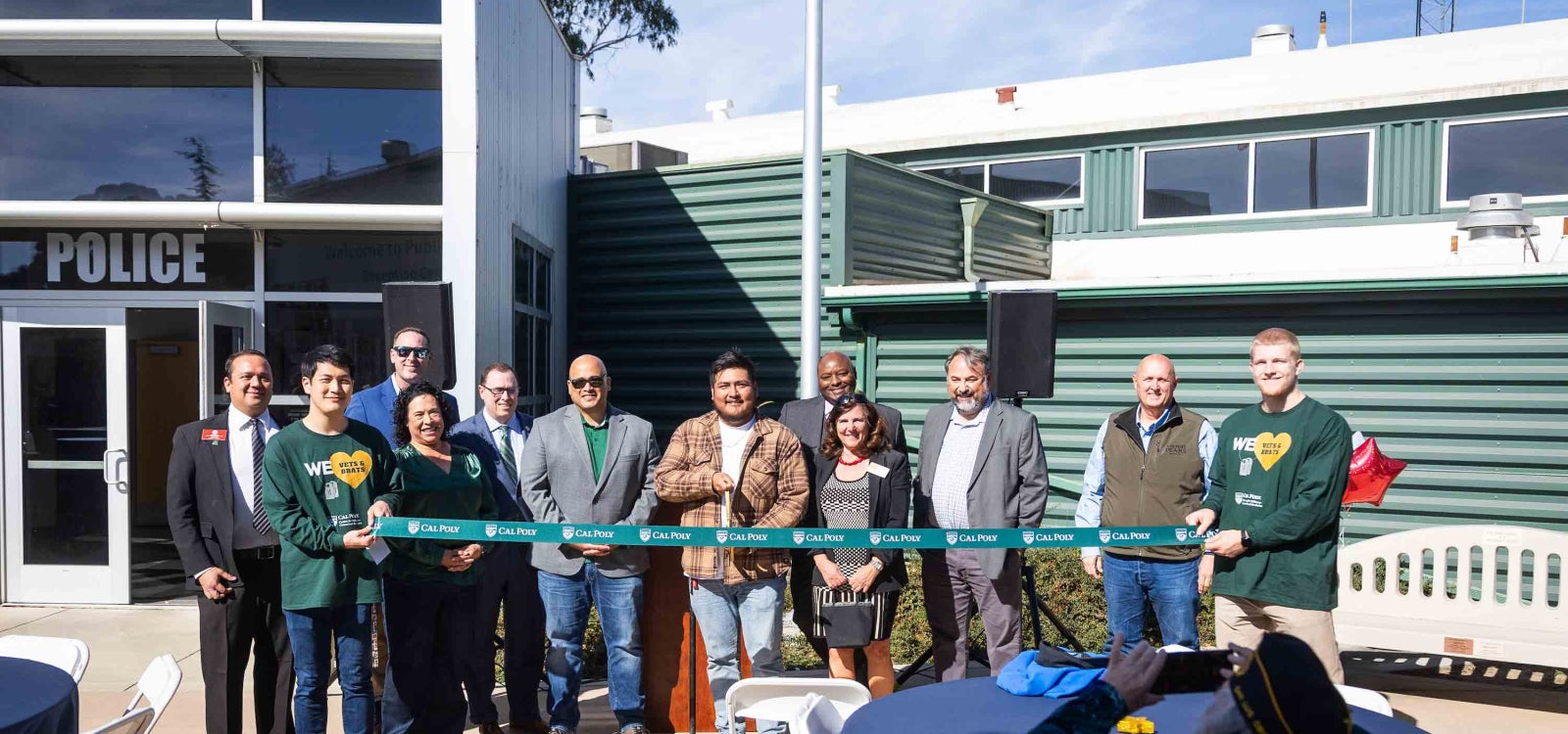 A Cal Poly student-veteran snaps the scissors with a dozen supporters at the ribbon cutting celebrating the dedication of the new center for military-connected students