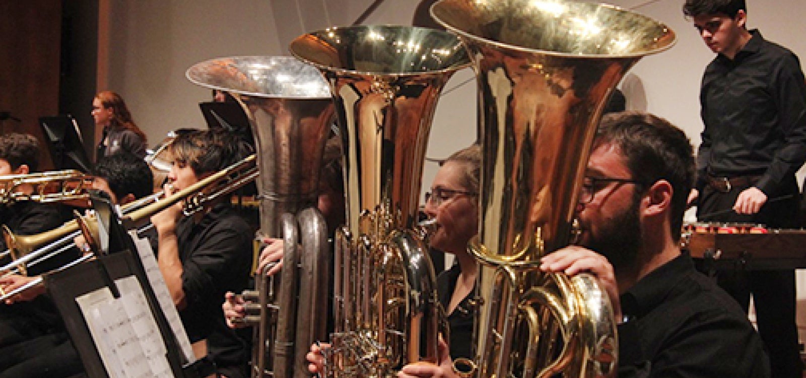 The horn section of the Cal Poly orchestra performs on stage