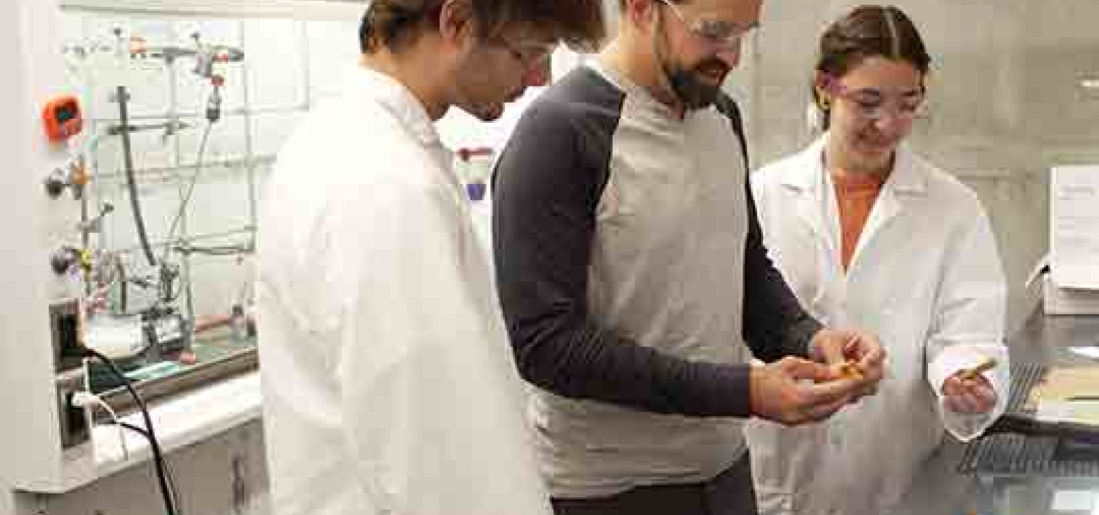 Cal Poly chemistry Professor Phil Costanzo with two students work in a lab on the debondable glue