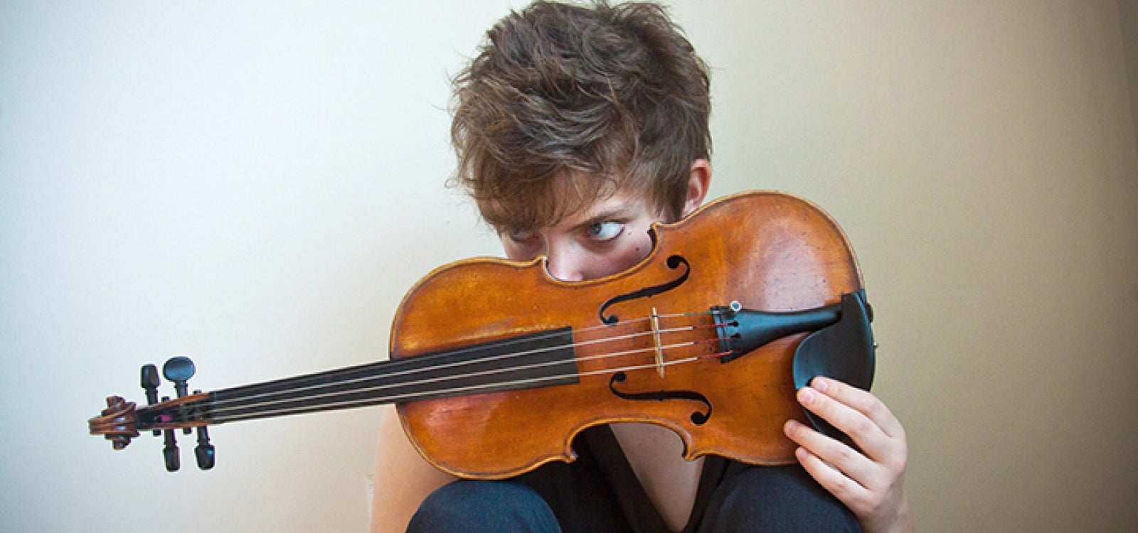 Violinist Sarah Saviet looks over the instrument