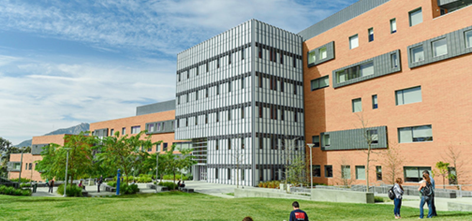 Students rest on the grass outside the Warren Baker Center for Science and Mathematics 
