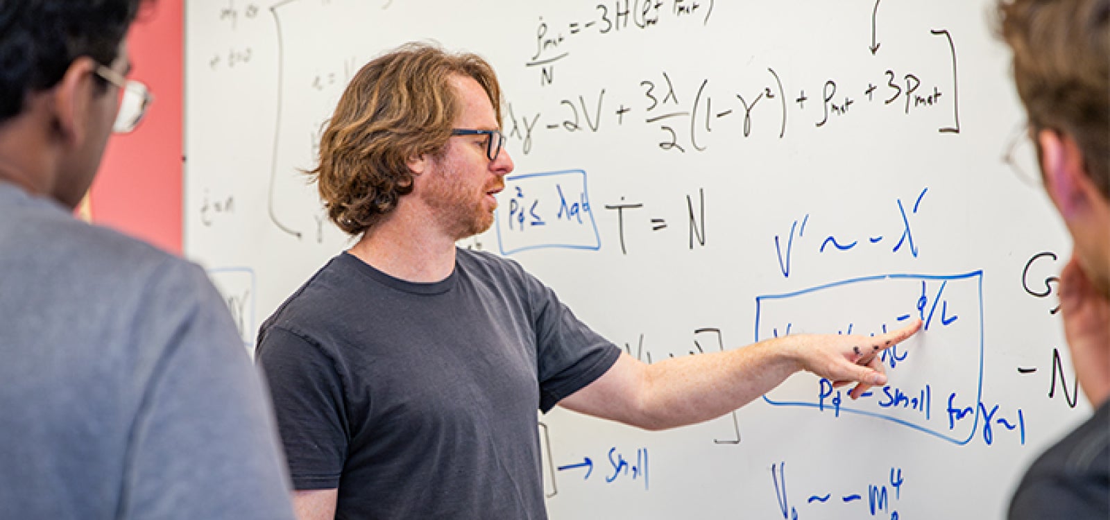Assistant Professor Ben Shlaer works with students on cosmology calculation