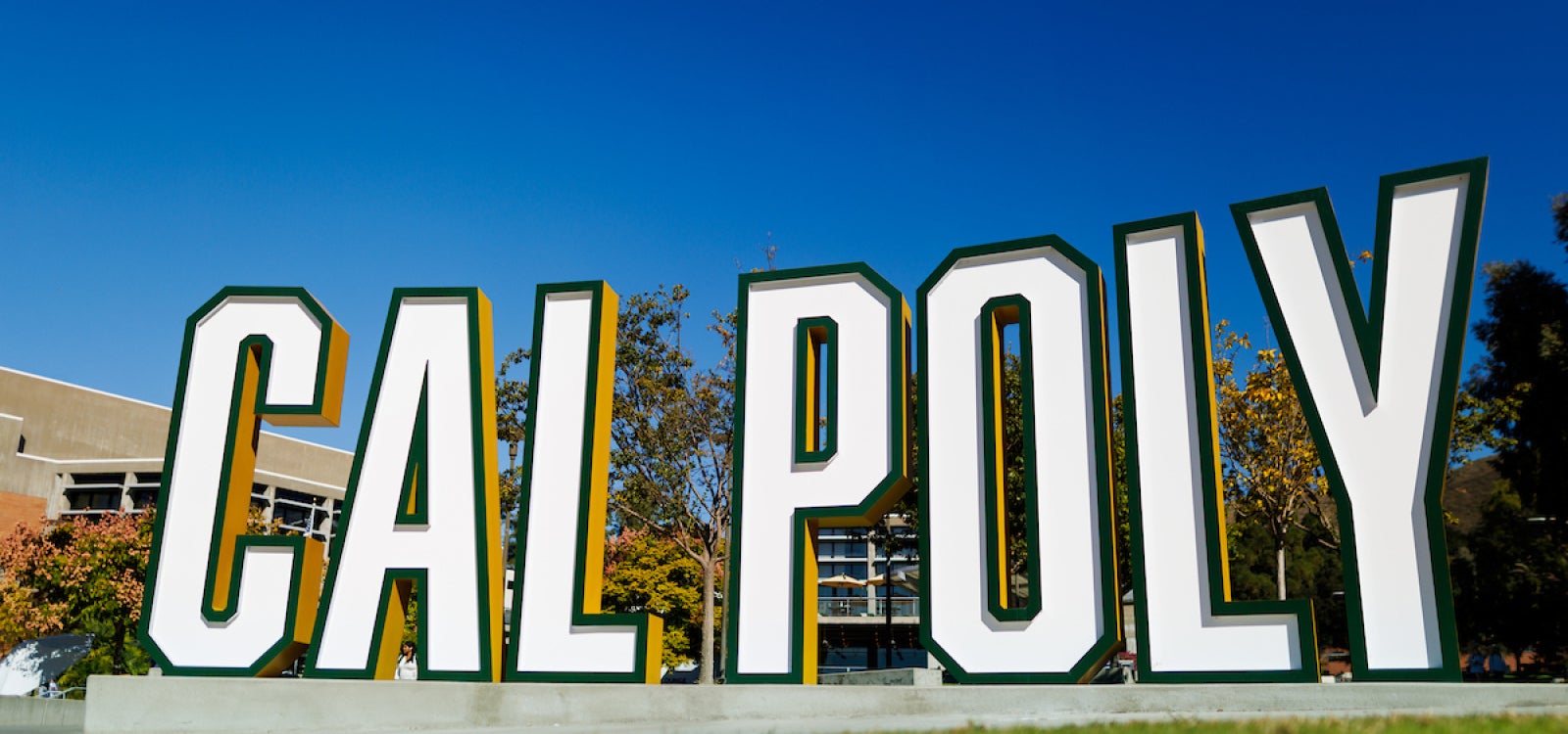 A free-standing sign spells our Cal Poly in large letters near the University Union