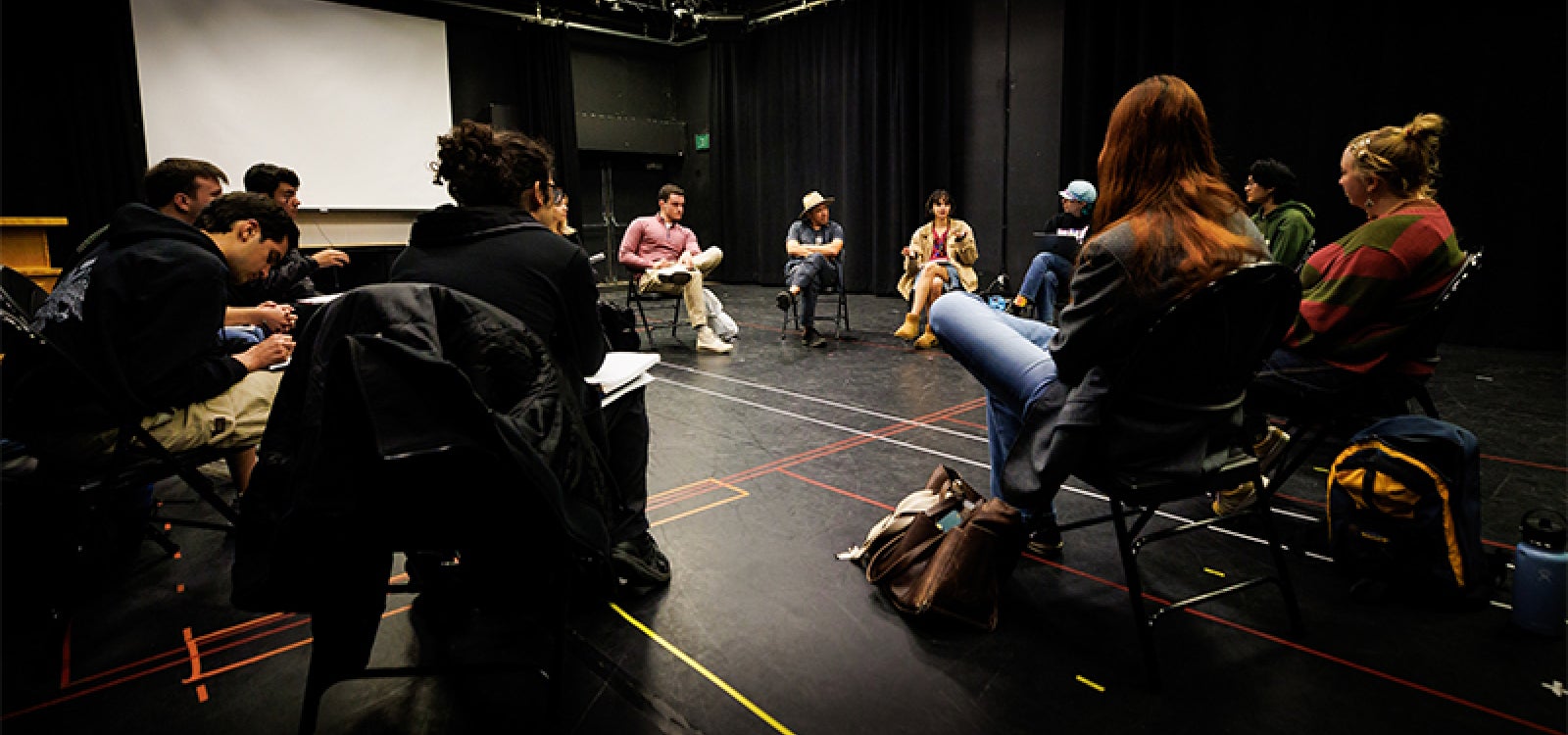 Students in Ancestral Theatre discuss the research on ancestries, genealogies, families and communities in the campus black box theater
