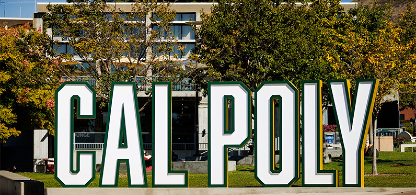 A free-standing sign spells our Cal Poly in large letters near the University Union
