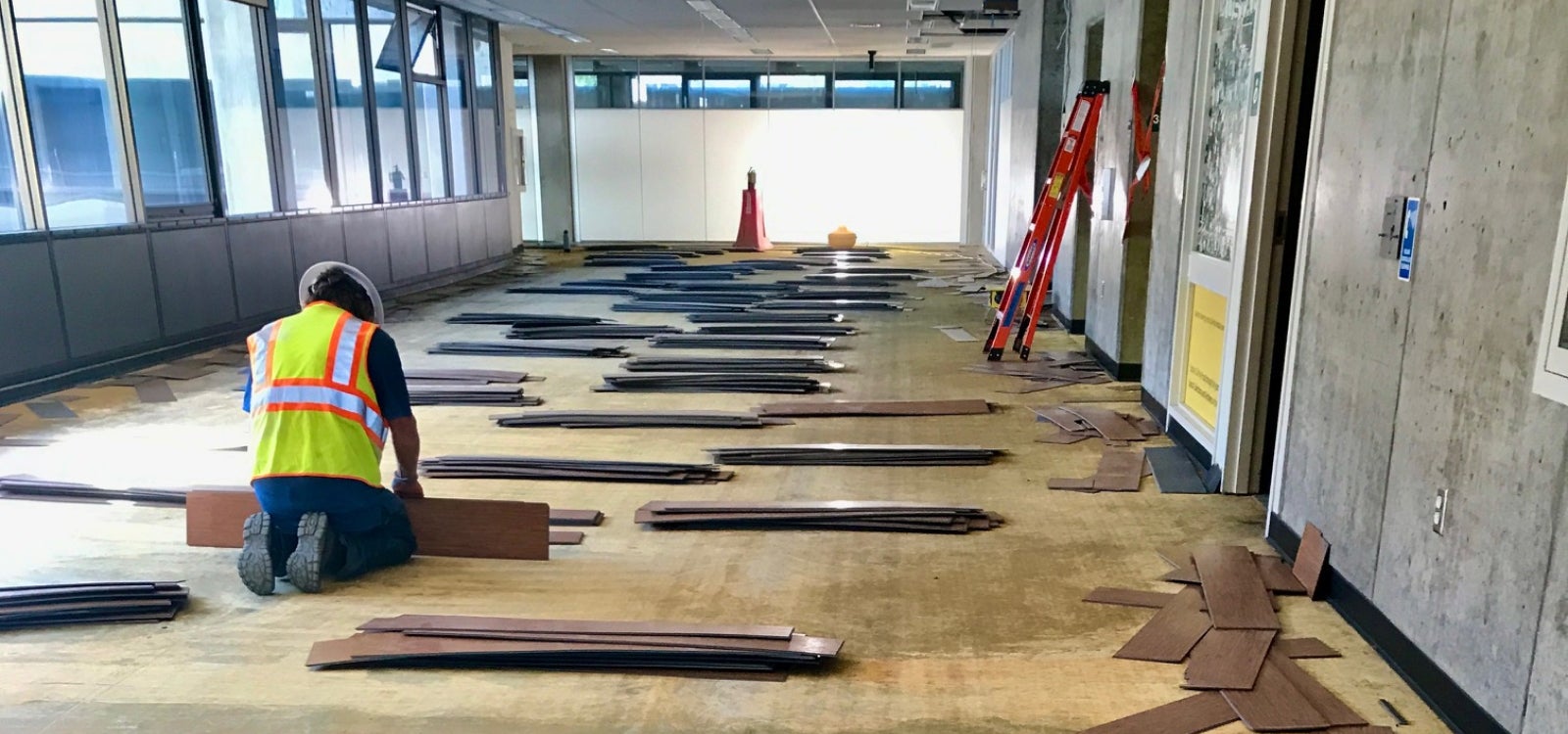 A workman stacks flooring removed from the Kennedy Library project