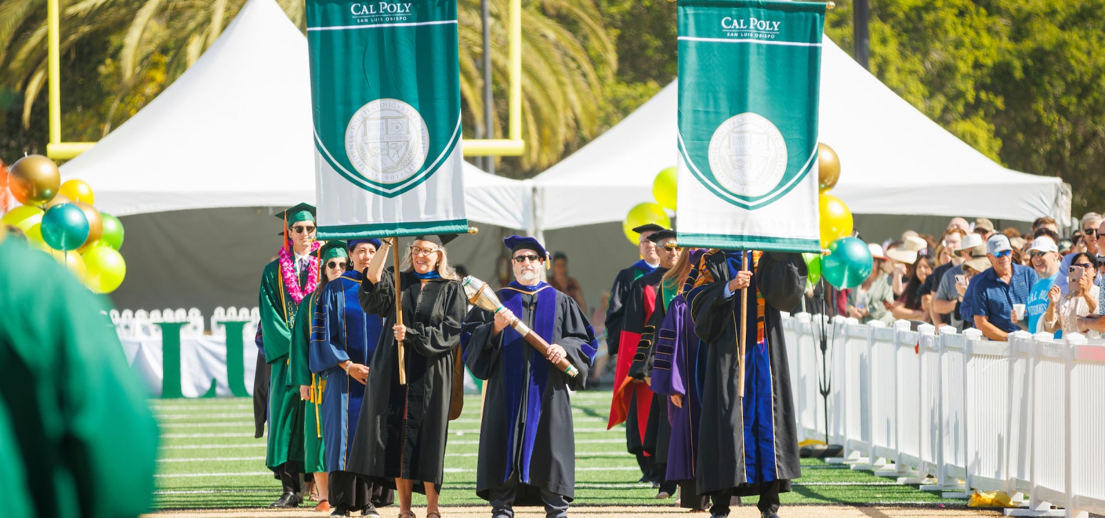The podium part led by the campus mace heads for the commencement stage in June 2023