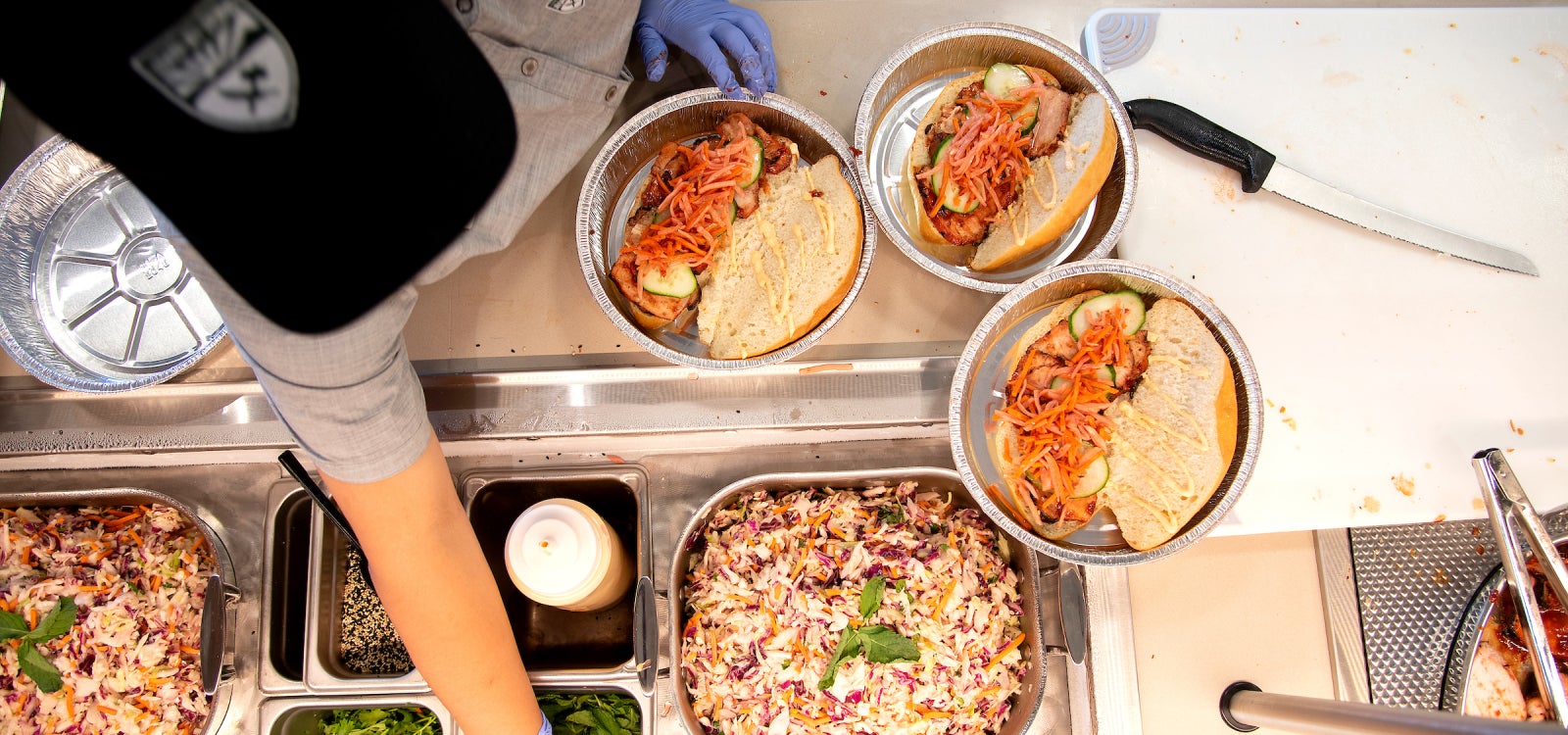 A Cal Poly Campus Dining worker completes to-go meals at Streats