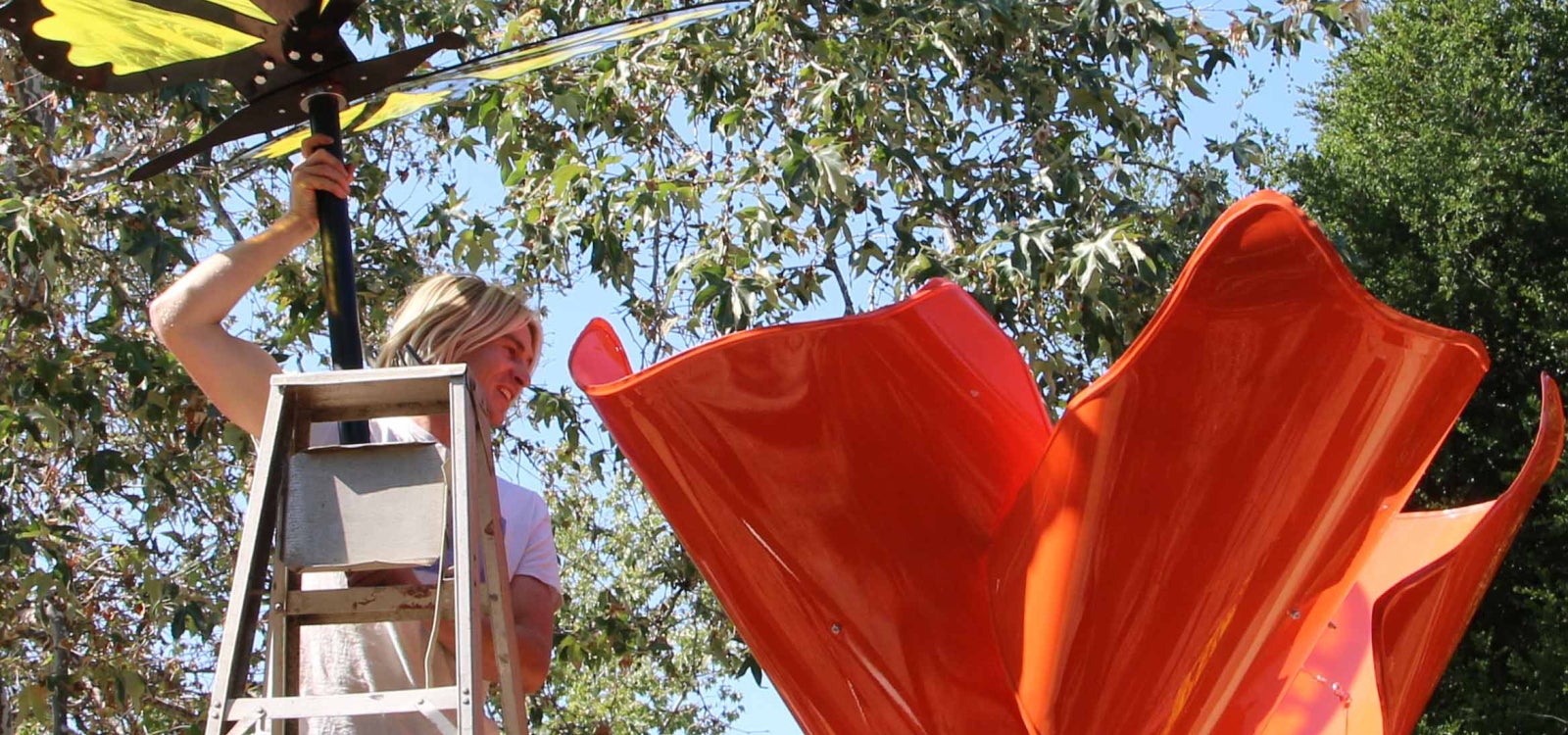 A student assembles a poppy and butterfly sculpture at the SLO Botanical Garden