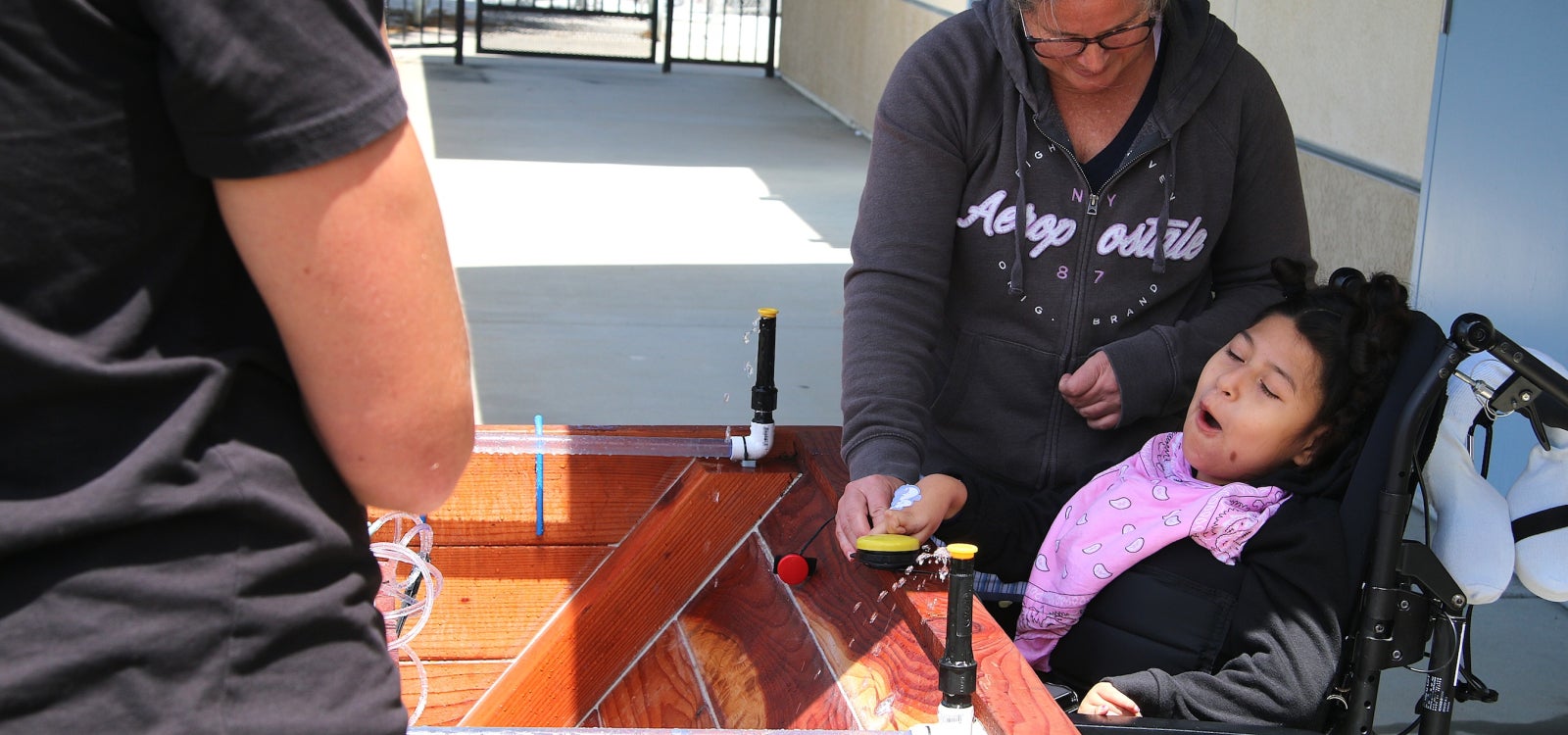 Heather McColley guides Marion as she presses a button on the garden box during the project’s first use at Oceano Elementary School.