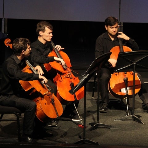 Three cellists performing