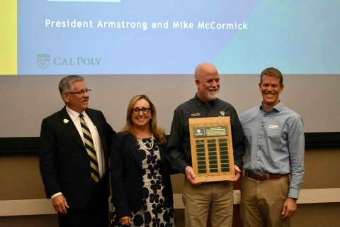 Dennis Elliot displays his perpetual namesake award alongside three other Cal Poly officials