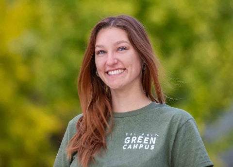 Kalea Conrad stands near a group of green and yellow foliage