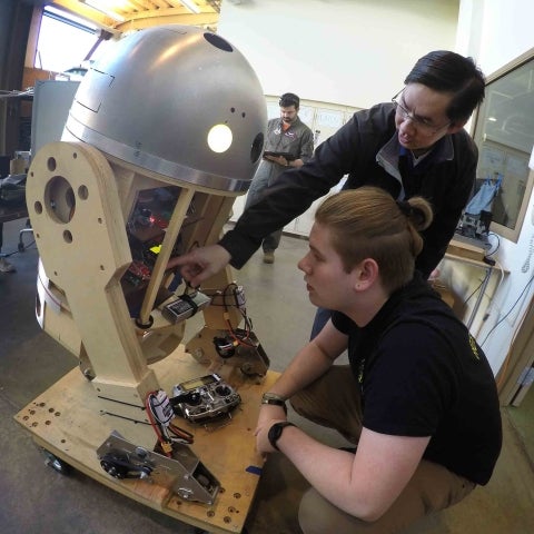 Cal Poly Robotics Club advisor and a student tinker with the club's robot Pascal