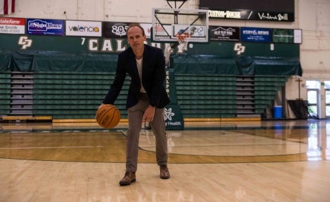 Associate Professor of economics Joseph Kuehn in Cal Poly’s Orfalea College of Business, holding a basketball, has been cited for his work analyzing what it takes to build a winning NBA team