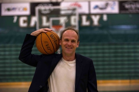 Associate Professor of economics Joseph Kuehn in Cal Poly’s Orfalea College of Business, holding a basketball, has been cited for his work analyzing what it takes to build a winning NBA team