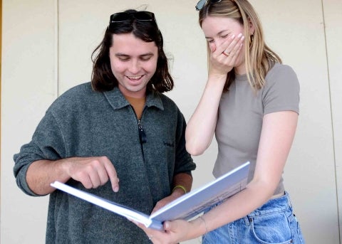 Yearbook editors Christian Gibson and Hannah Scroggins share a laugh while examining the yearbook