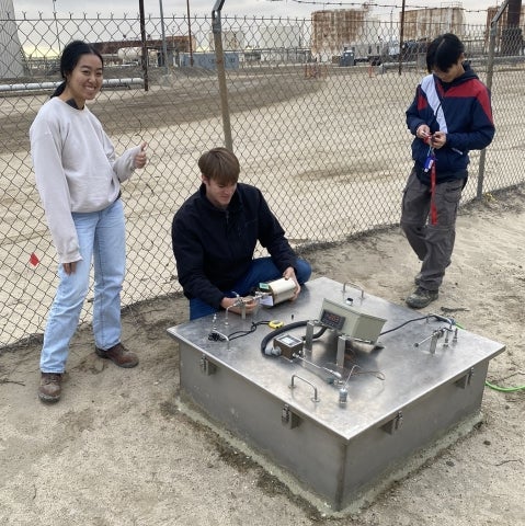 Cal Poly engineering students collect a gas sample from a custom-built flux chamber