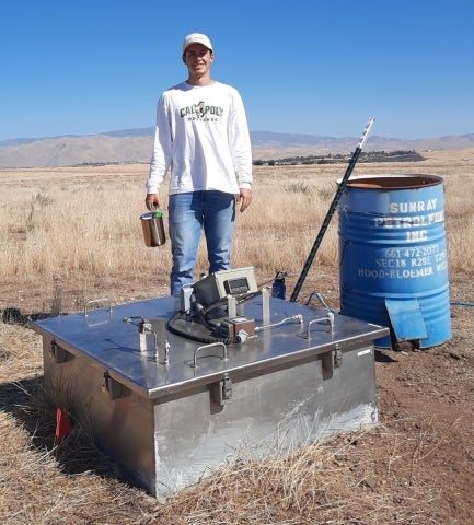 Cal Poly student Ryan Luzzi readiest take a gas sample from a flux chamber at a testing site