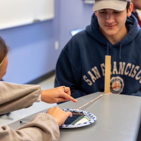 Students conduct an experiment using a smartphone