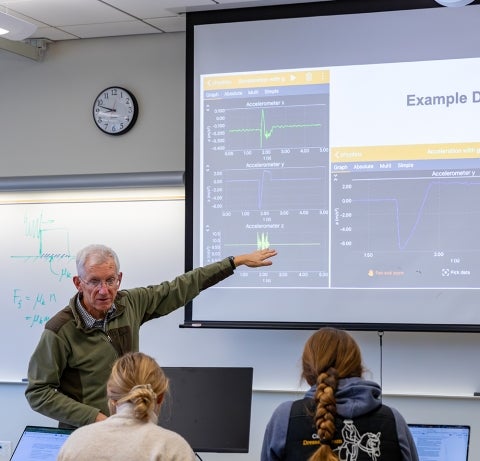 physics Professor Matt Moelter discusses data collection with students in a physics lab