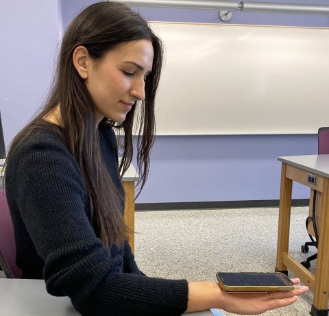 A student  conducts an experiment on hand tremors using the Physics with Phones