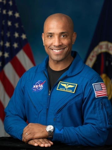 Victor Glover wears his NASA flight suit in an official portrait