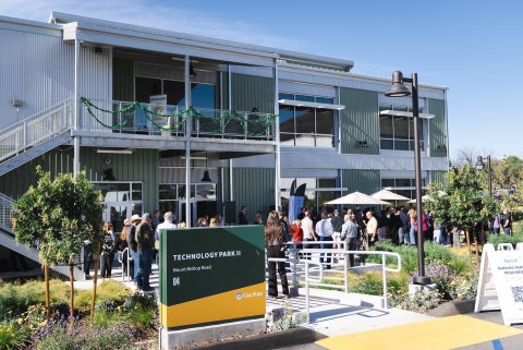 Attendees celebrate at the ribbon cutting for the opening of the second phase of the Tech Park on Mount Bishop Road