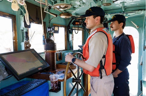 Two Cal Poly Maritime Academy cadets staff the Golden Bear's helm