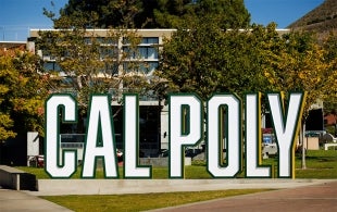 A free-standing sign spells our Cal Poly in large letters near the University Union