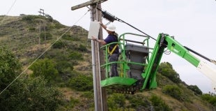 A technician installs equipment to expand private wireless connectivity in Poly Canyon