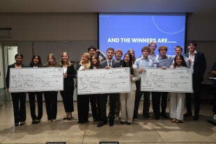 tartup Launch Weekend winners celebrate with their checks after pitching their startup concepts