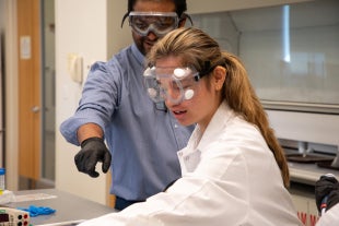 Professor Javin Oza works in lab with biochemistry in the Engineering Synthetic Cells course
