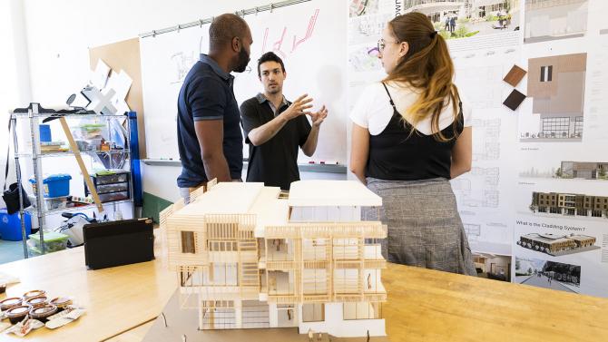 Students present architectural models to professor