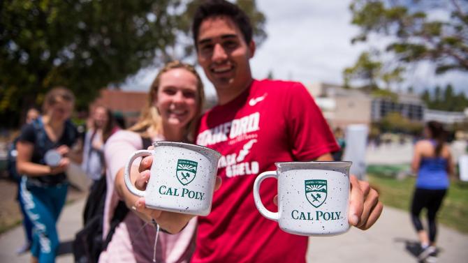 Students hold two Cal Poly branded mugs toward the camera.