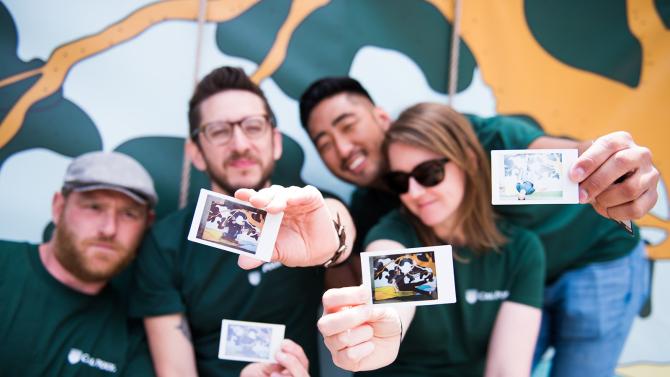 four members of the ucm group pose with polaroids during the brand preview event