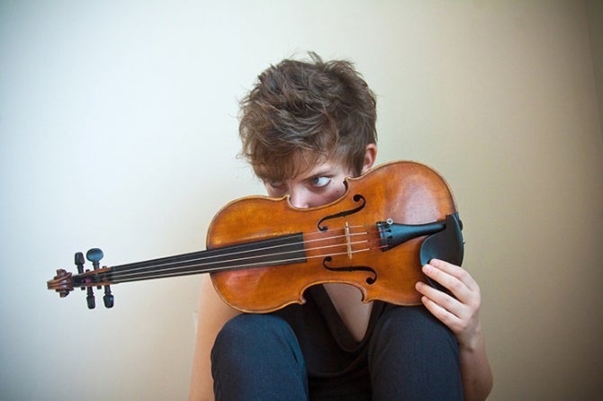 Violinist Sarah Saviet looks over the instrument