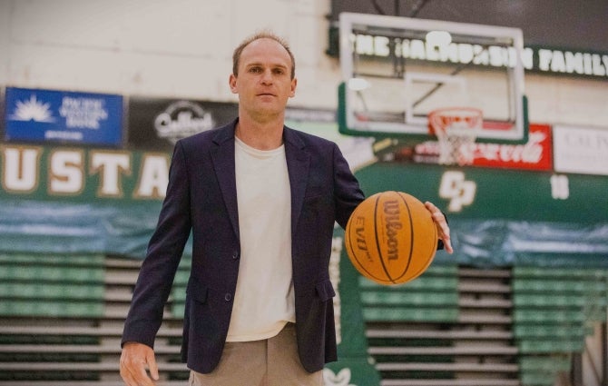 Associate Professor of economics Joseph Kuehn in Cal Poly’s Orfalea College of Business, holding a basketball, has been cited for his work analyzing what it takes to build a winning NBA team