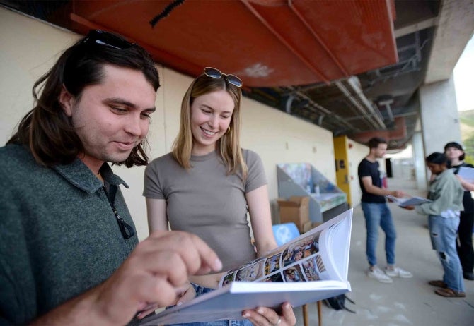 Yearbook editors Christian Gibson and Hannah Scoggins and a group of architecture students examine the student-created yearbook