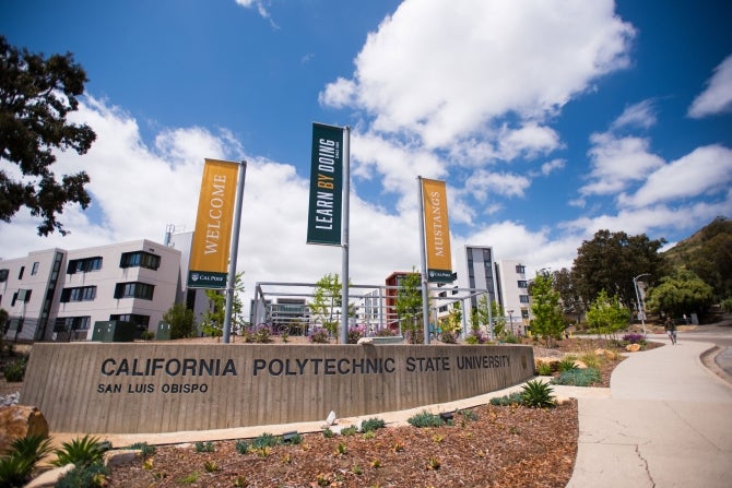 The entrance to Cal Poly on Grand Avenue showing vertical banners that state Welcome, Mustangs and Learn by Doing