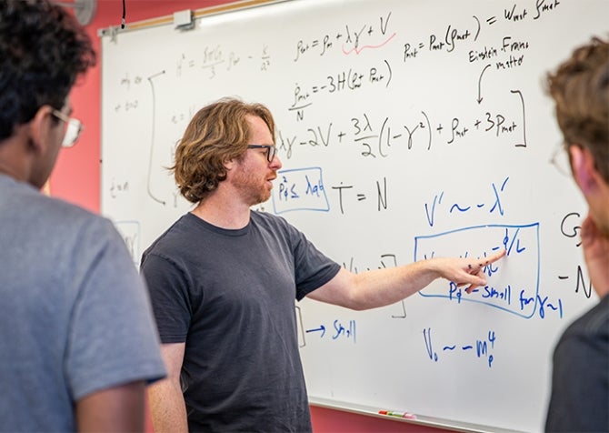 Assistant Professor Ben Shlaer works with students on cosmology calculation