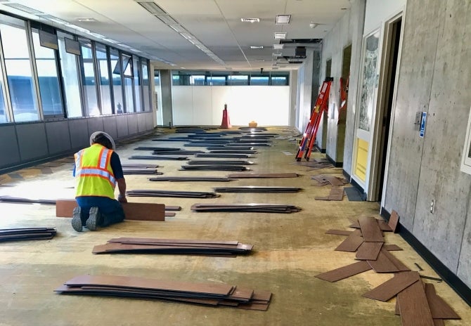 A workman stacks flooring removed from the Kennedy Library project